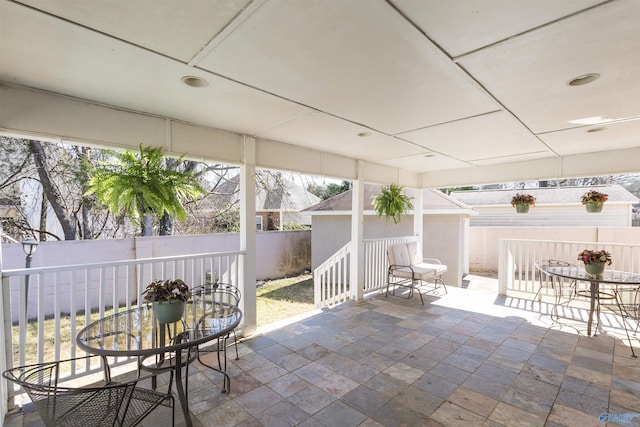 view of patio featuring an outbuilding, outdoor dining area, and a fenced backyard