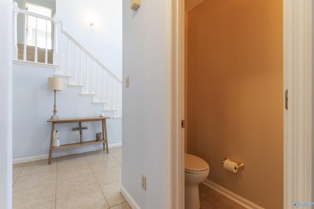 bathroom with tile patterned flooring, toilet, and baseboards