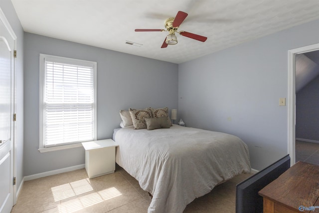 bedroom featuring light tile patterned floors, baseboards, visible vents, and ceiling fan