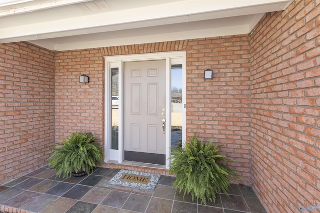 doorway to property featuring brick siding