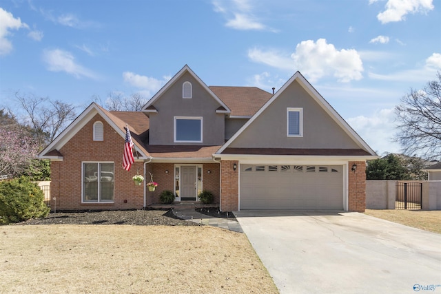 traditional-style house with a garage, brick siding, driveway, and fence