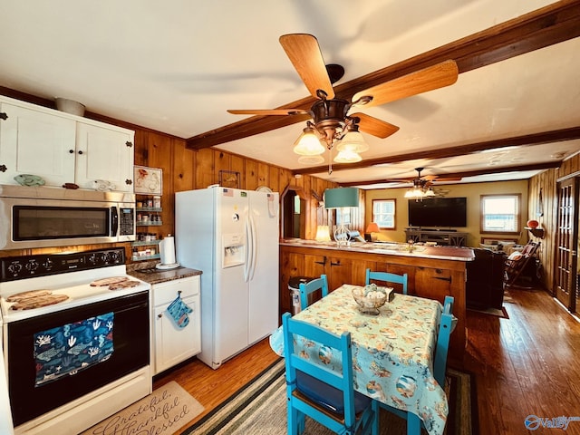 kitchen with light wood-style flooring, beamed ceiling, stainless steel microwave, range with electric stovetop, and white refrigerator with ice dispenser
