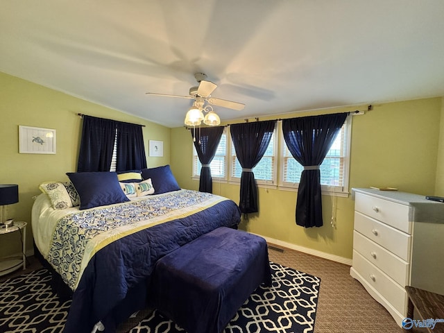 carpeted bedroom featuring baseboards, vaulted ceiling, and ceiling fan
