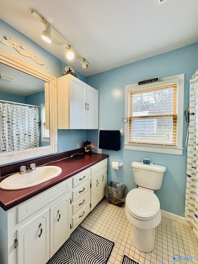 bathroom with tile patterned flooring, vanity, baseboards, and visible vents