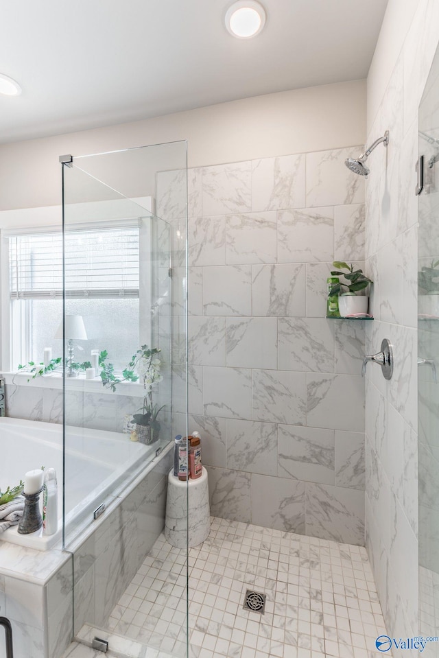 bathroom featuring shower with separate bathtub