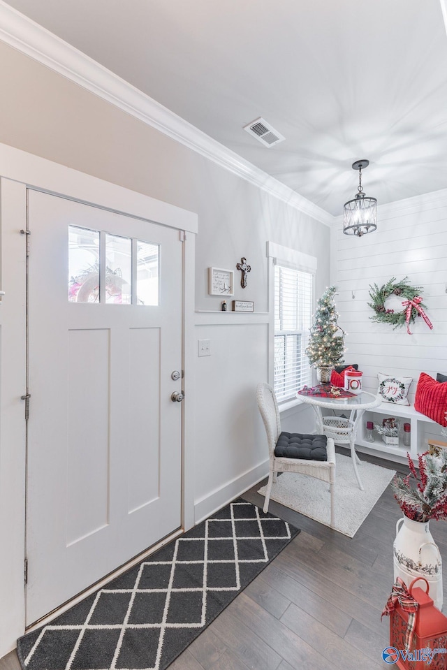 entryway featuring a chandelier, ornamental molding, dark hardwood / wood-style floors, and a healthy amount of sunlight