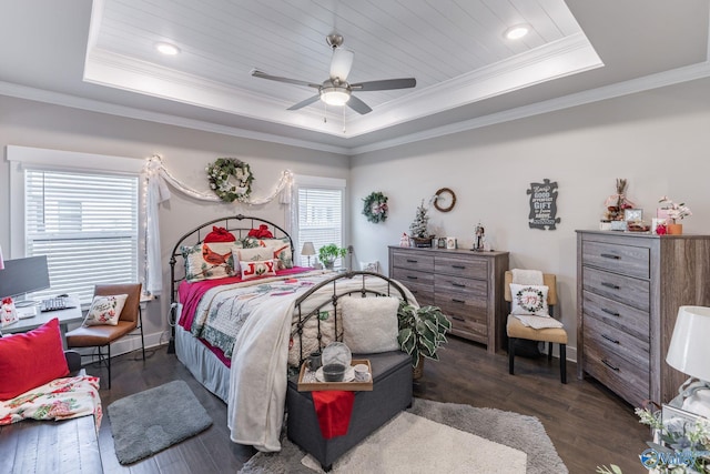 bedroom with dark hardwood / wood-style flooring, a tray ceiling, and multiple windows