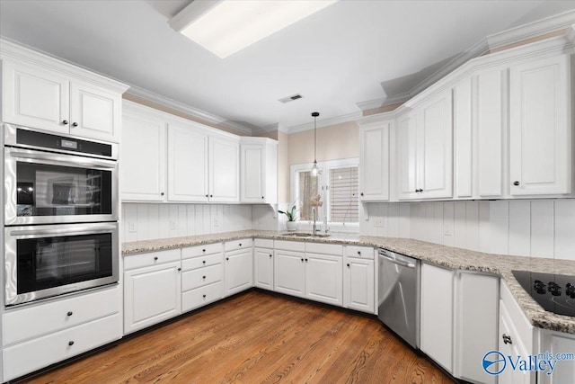 kitchen featuring visible vents, appliances with stainless steel finishes, and white cabinets