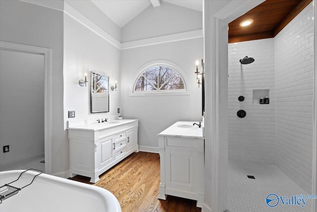 full bath with lofted ceiling with beams, vanity, wood finished floors, tiled shower, and baseboards