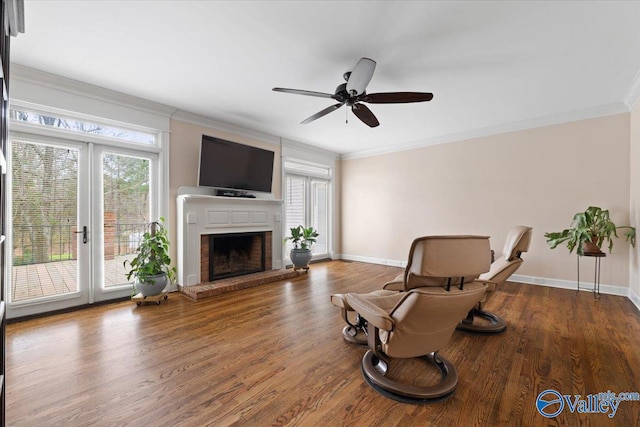 sitting room with ornamental molding, a fireplace, and wood finished floors