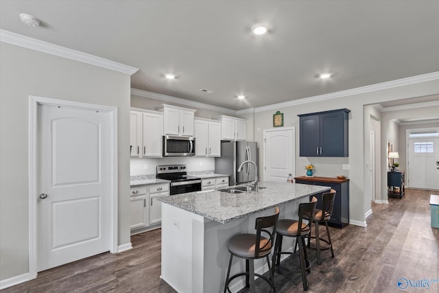 14930 Eva Cir, Athens, AL 35613 - kitchen with stainless steel appliances, a center island with sink, dark wood-style flooring, ornamental molding, and a kitchen breakfast bar