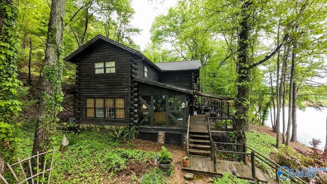 back of property with a wooden deck and log siding