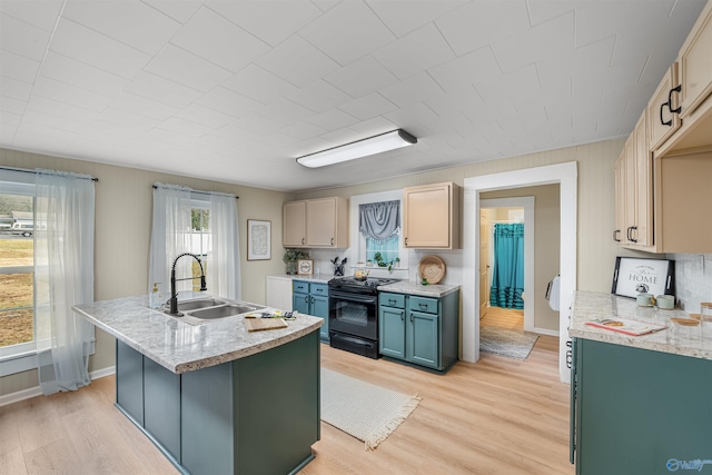 kitchen featuring black electric range oven, light brown cabinets, sink, decorative backsplash, and light wood-type flooring