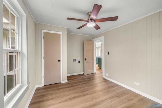 empty room featuring ceiling fan, ornamental molding, and light hardwood / wood-style flooring