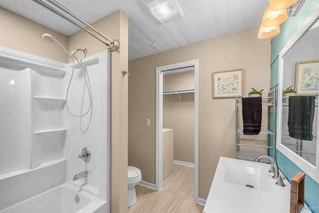 full bathroom with sink, hardwood / wood-style floors,  shower combination, and toilet