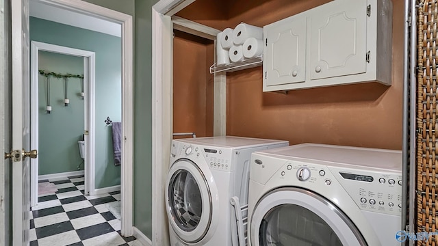 clothes washing area featuring independent washer and dryer and cabinets