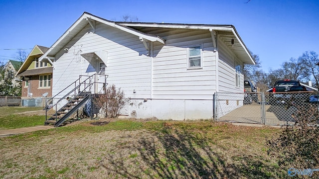 view of property exterior with cooling unit and a lawn