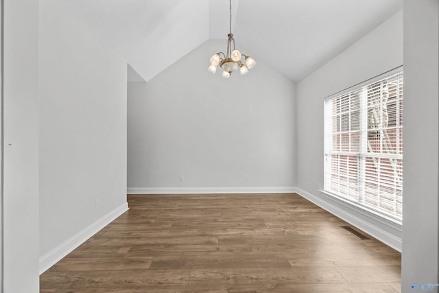 unfurnished dining area featuring lofted ceiling, a notable chandelier, and wood-type flooring