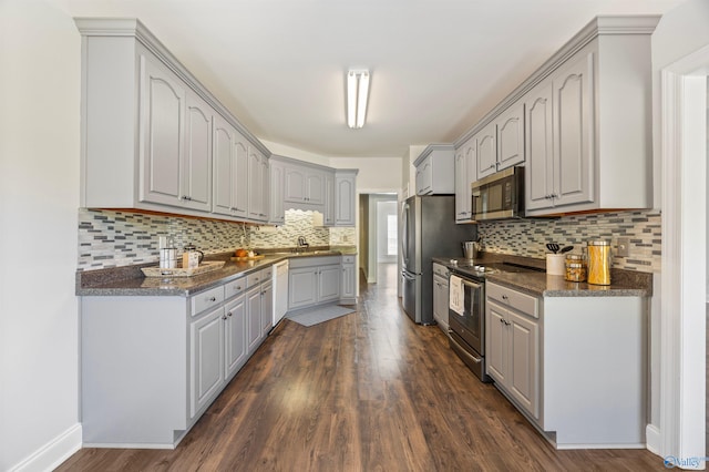 kitchen featuring decorative backsplash, gray cabinetry, stainless steel appliances, sink, and dark hardwood / wood-style flooring