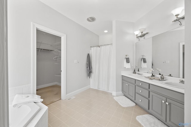 bathroom with vanity and a relaxing tiled tub