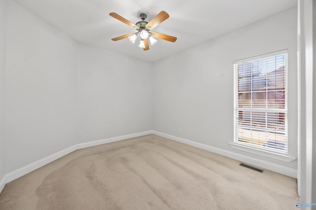 carpeted spare room featuring ceiling fan