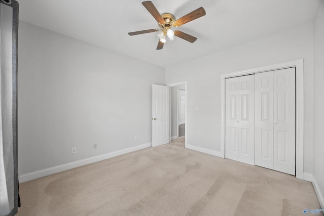 unfurnished bedroom featuring light carpet, a closet, and ceiling fan