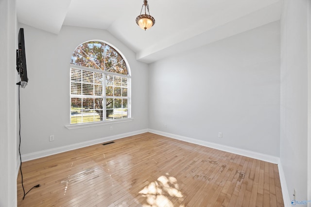 unfurnished room with lofted ceiling and hardwood / wood-style floors