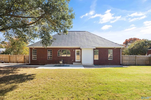 rear view of property featuring a yard and a patio area