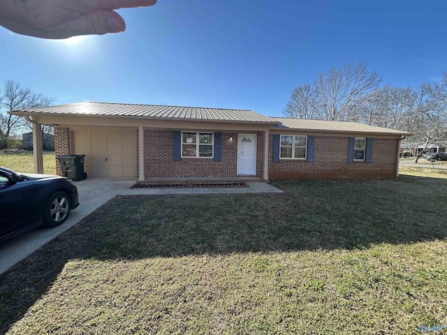 393 Canadian Dr, Scottsboro, AL 35769 - single story home with a garage, metal roof, concrete driveway, a front yard, and brick siding