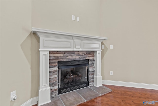 room details featuring hardwood / wood-style flooring and a stone fireplace