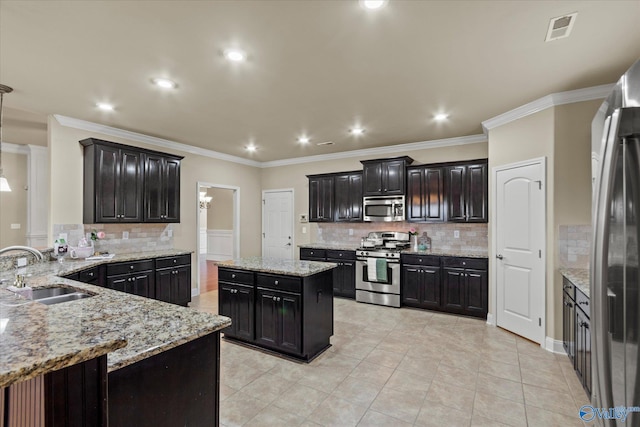 kitchen featuring sink, light tile patterned floors, light stone counters, a kitchen island, and appliances with stainless steel finishes