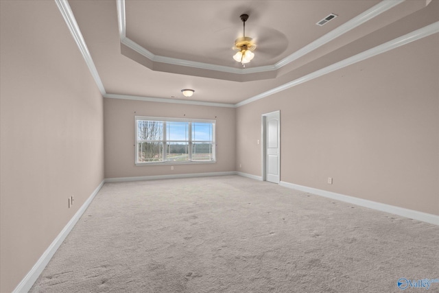 spare room featuring light colored carpet, a raised ceiling, ceiling fan, and ornamental molding