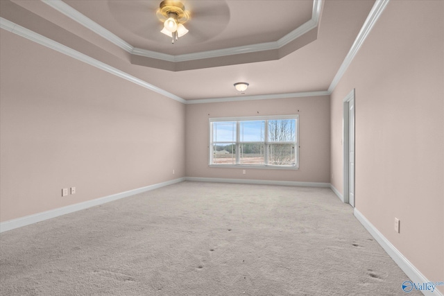 carpeted spare room with a raised ceiling, ceiling fan, and crown molding