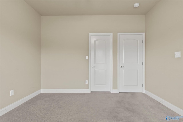 unfurnished room featuring light colored carpet