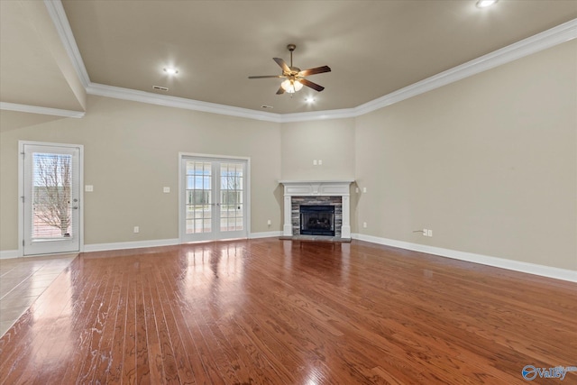 unfurnished living room with hardwood / wood-style flooring, ceiling fan, crown molding, and a fireplace