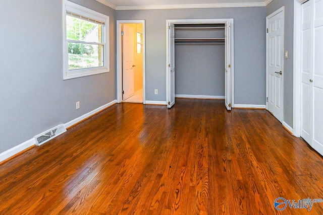 unfurnished bedroom with ornamental molding and dark wood-type flooring