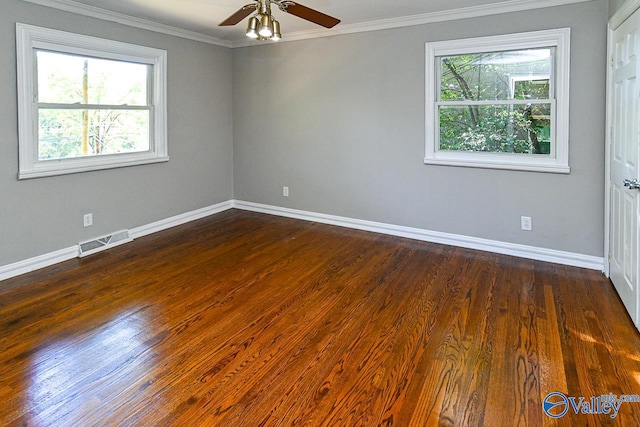 empty room with plenty of natural light, dark hardwood / wood-style floors, ornamental molding, and ceiling fan