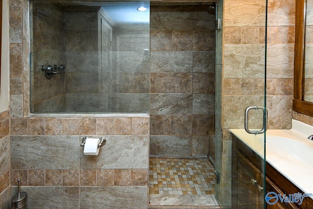 bathroom featuring a shower with door and vanity