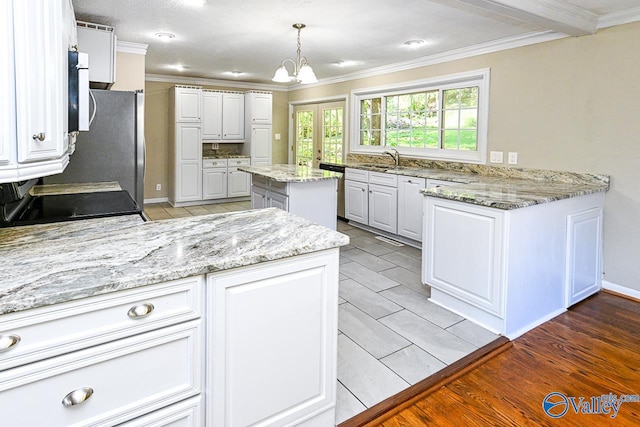 kitchen with a kitchen island, light stone counters, white cabinets, light hardwood / wood-style floors, and hanging light fixtures