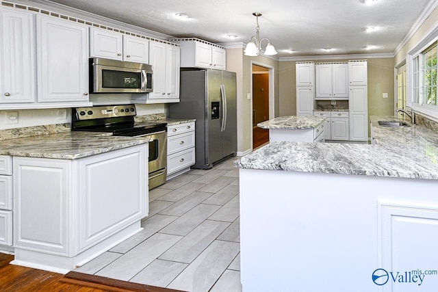 kitchen featuring appliances with stainless steel finishes, hanging light fixtures, white cabinetry, and a center island