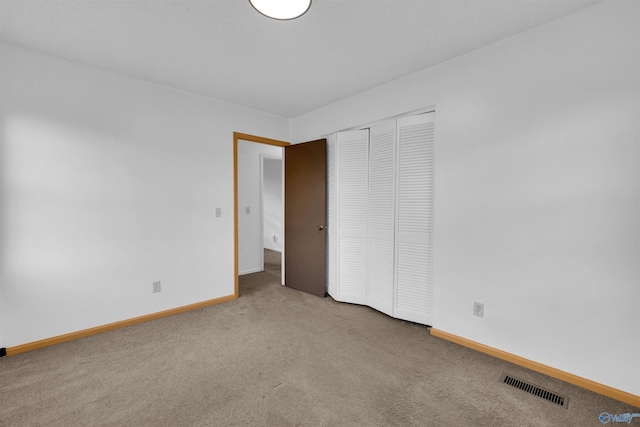 unfurnished bedroom featuring a closet and carpet flooring