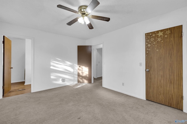 carpeted empty room featuring ceiling fan