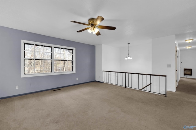 unfurnished room with carpet floors and ceiling fan with notable chandelier