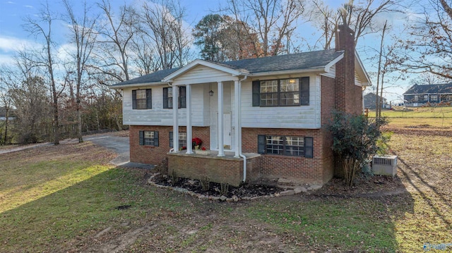 bi-level home featuring central AC unit and a front yard