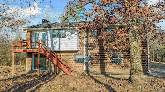 rear view of property featuring a wooden deck