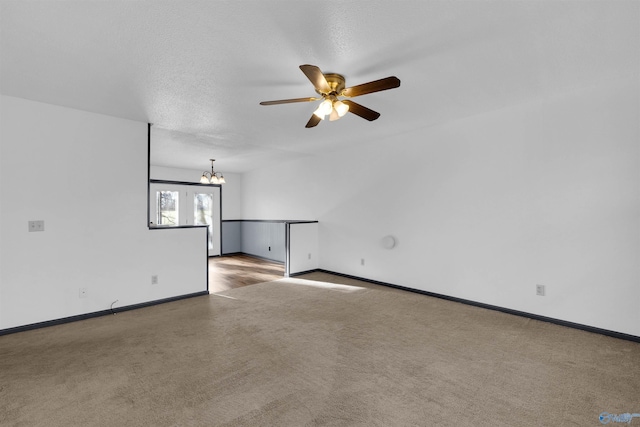 empty room featuring ceiling fan with notable chandelier