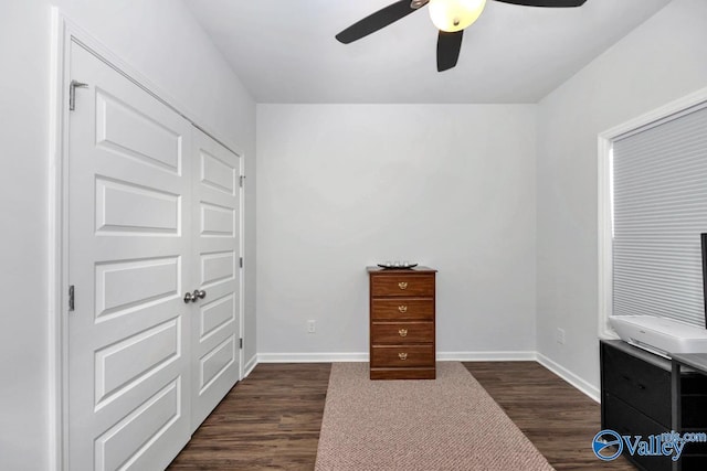 unfurnished bedroom with ceiling fan, dark wood-type flooring, and a closet