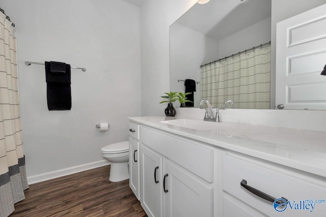 bathroom featuring toilet, vanity, and hardwood / wood-style floors