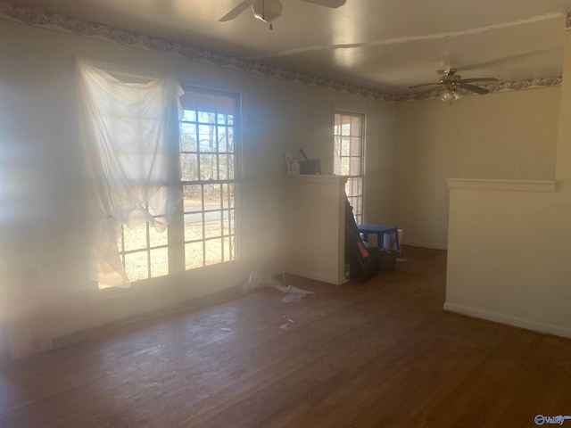 empty room with ceiling fan, baseboards, and wood finished floors