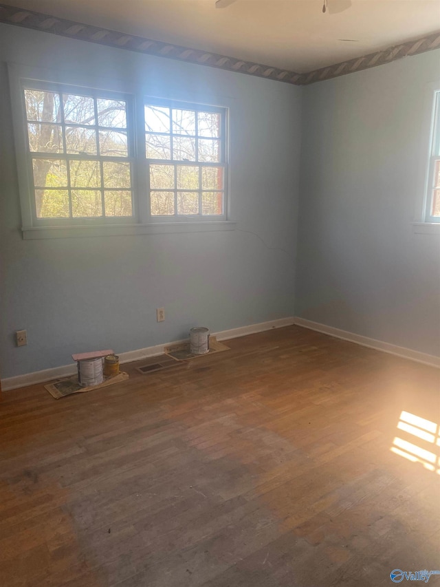 empty room featuring baseboards and wood finished floors